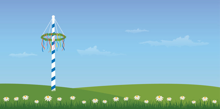 maypole with colorful ribbons on green meadow