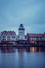 Obraz premium old houses and a lighthouse on the embankment