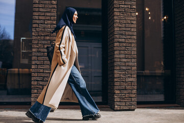 Young muslim woman student walking in the street