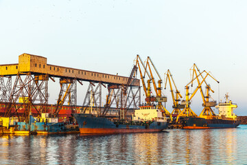 A dry cargo ship and a tanker ship are standing at the port of Constanta Romania and are being loaded. - obrazy, fototapety, plakaty