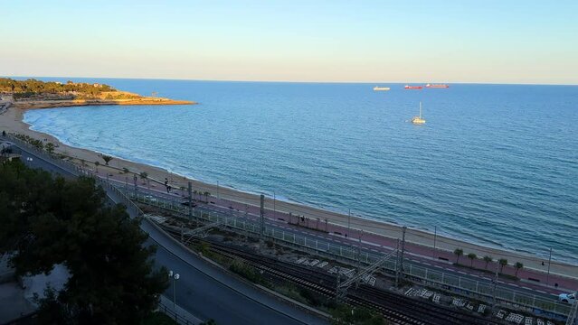 Panoramic view of coast of Tarragona, beach in La Pineda with railway tracks along coastline , Catalunya, Spain. High quality 4k footage