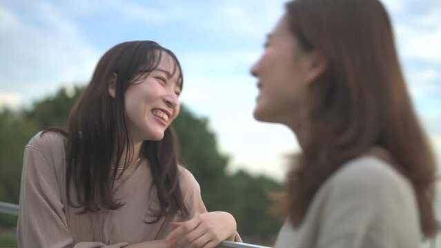 テラスで楽しそうにおしゃべりする二人の女性