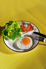 healthy ketogenic breakfast with fried egg, green salad and smoked salmon