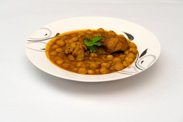 Chicken chana (Murgh chana) an indian street food made of chicken, chickpeas, tomatoes and cumin in plate on whtie background.                           