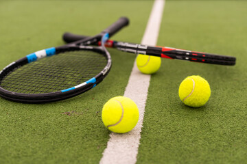 Tennis racket and tennis ball on court.