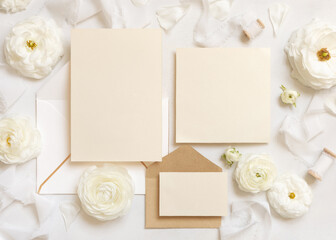 Blank cards and envelopes near cream roses and white ribbons top view, wedding mockup