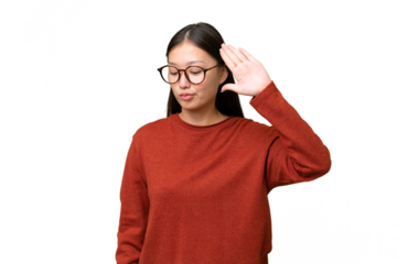 Young Asian woman over isolated background listening to something by putting hand on the ear