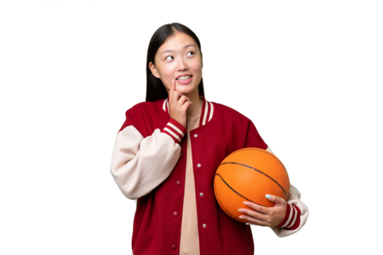 Young basketball player asian woman over isolated background thinking an idea while looking up