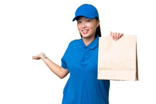 Young Asian woman taking a bag of takeaway food over isolated background extending hands to the side for inviting to come