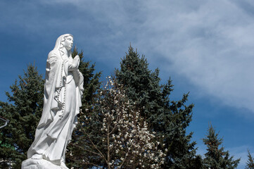 statue of the Virgin in nature under the rays of the sun