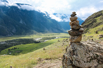 Stone pyramid in river valley Chulyshman. Natural landscape Republic Altai, Russia, summer day. mountain in clouds