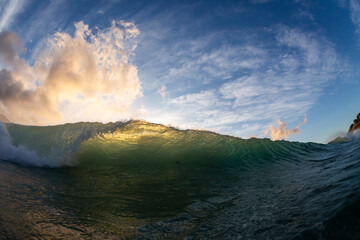 Obraz premium sunset over the sea with a crashing wave and dramatic sky