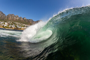 huge wave crashing in the sea with a blue sky background in cape town south africa