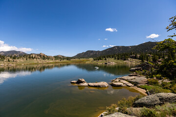wide open landscape with a lake and mountains