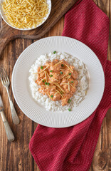 Brazilian style Chicken strogonoff with rice and potato straw on wooden table. Flat lay