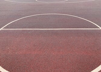 Dark red sport court outdoor. Street basketball court. Abstract. Rubber ground with white lines. Top view.