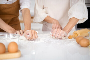 Obraz na płótnie Canvas Close up view of bakers are working. Homemade bread. Hands preparing dough on table for homemade pastry and bread. Cooking and baking at home concept.hands of the baker's female knead dough .
