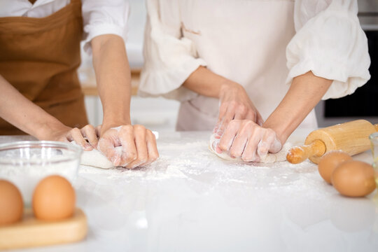 Close up view of bakers are working. Homemade bread. Hands preparing dough on table for homemade pastry and bread. Cooking and baking at home concept.hands of the baker's female knead dough .