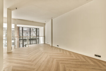 an empty living room with wood flooring and large sliding glass doors leading to the balcony area in this apartment
