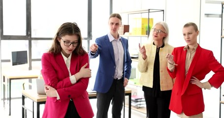 Employees in the office are ashamed of a colleague, a close-up. Psychological pressure at the workplace, mobbing