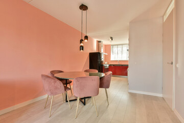 a dining room with pink walls and wood flooring in the center of the room, there is an open door leading to the