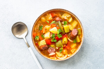 Minestrone soup, italian vegetable soup with smoked sausages, Top view. - obrazy, fototapety, plakaty