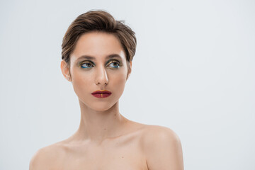 portrait of young woman with shiny makeup and short hair isolated on grey.
