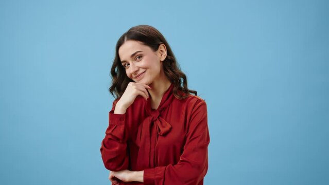 Young woman winks seductively and beckons crooking finger