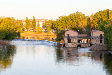 Aceñas (molinos de agua) de Cabañales en el río Duero a su paso por Zamora, en la puesta de sol. Castilla y León, España. - obrazy, fototapety, plakaty