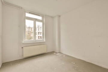 an empty room with white walls and no one person standing on the floor in front of the window looking out to the street