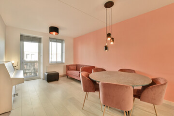 a living room with pink walls and white flooring in the center of the room is a dining table, two chairs and a