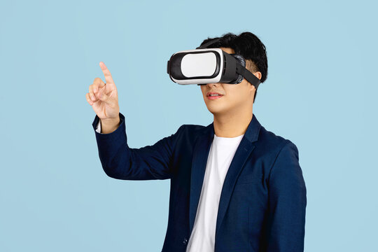 Asian using VR headset smile with hand pointing to space on web banner light blue background.