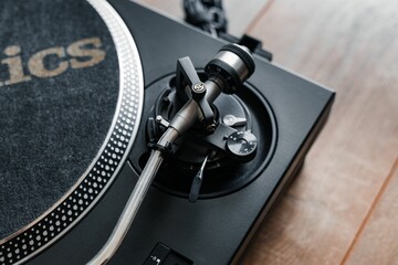 Detailed shot of a vintage turntable, with spinning center, tonearm, and a record on the platter