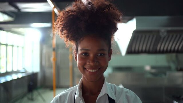 Happy cheerful junior Asian chef showing a beautiful smile to camera while in kitchen.