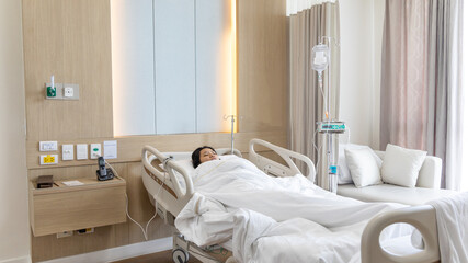 Patient lying on an inpatient bed in the recovery room treating the illness and being closely monitored by a physician, Modern Adjustable Patient Bed in Hospital, Service point in a modern hospital