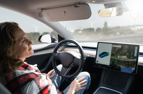 Woman resting while her car is driven by an autopilot. Self driving vehicle concept	