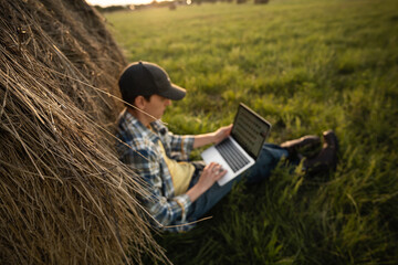 Farmer with laptop on the field. Smart farming and agriculture digitalization	