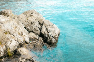 High angle shot of rocks in a crystal-clear sea on a sunny day