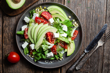 Salad with feta cheese, avocado and tomatoes in a bowl