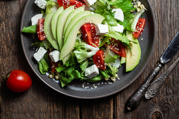 Salad with feta cheese, avocado and tomatoes in a bowl