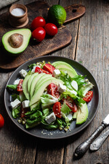 Salad with feta cheese, avocado and tomatoes in a bowl