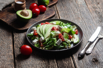 Salad with feta cheese, avocado and tomatoes in a bowl