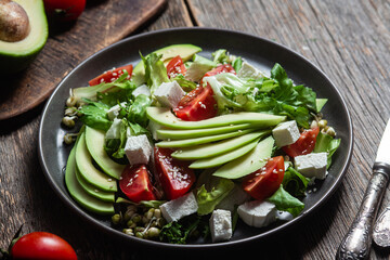 Salad with feta cheese, avocado and tomatoes in a bowl