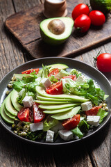 Salad with feta cheese, avocado and tomatoes in a bowl