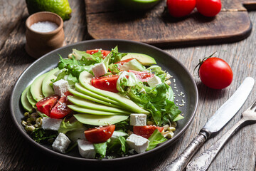 Salad with feta cheese, avocado and tomatoes in a bowl