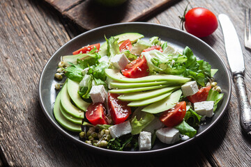 Salad with feta cheese, avocado and tomatoes in a bowl