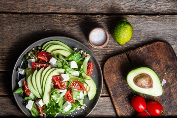 Salad with feta cheese, avocado and tomatoes in a bowl