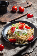 Spaghetti with feta cheese and tomatoes in a plate. Italian pasta
