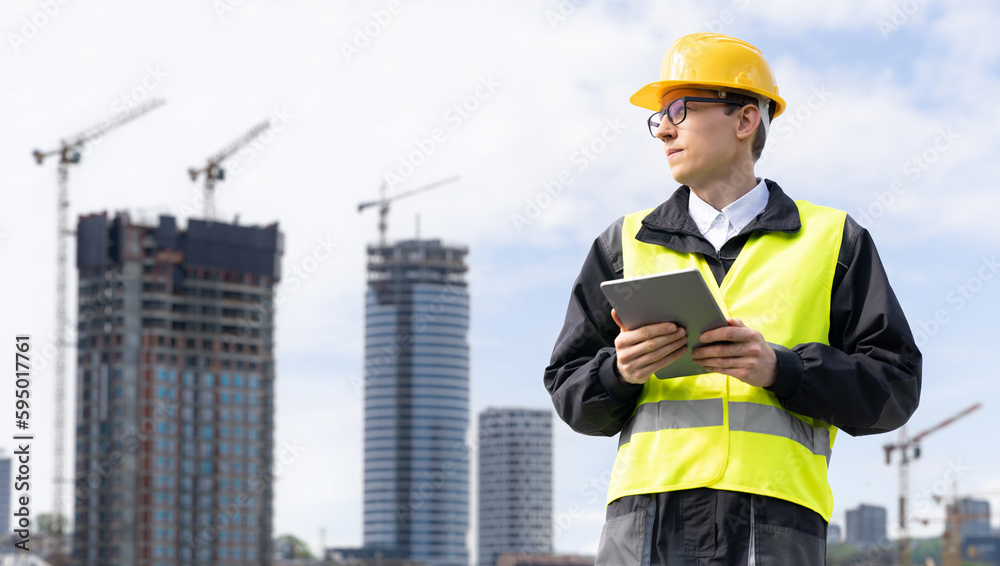 Aufkleber engineer with a digital tablet on the background of a building under construction
