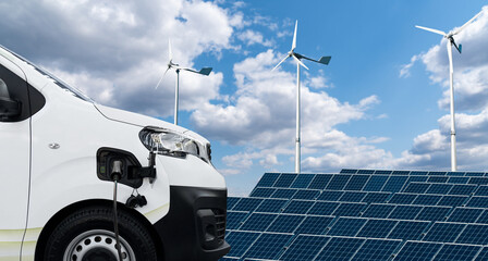 Electric van on a background of solar panel and wind turbines.	